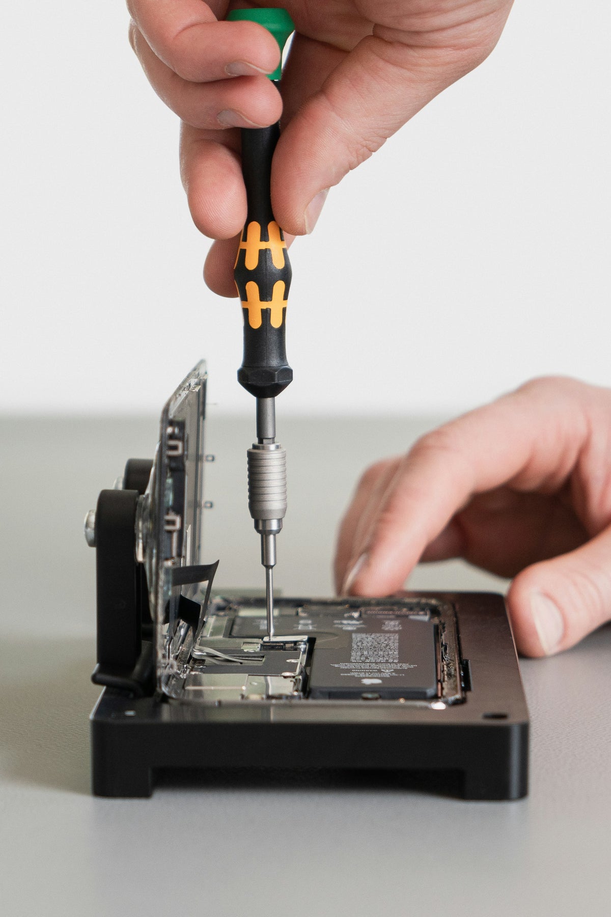 Precision screwdriver working inside an opened smartphone